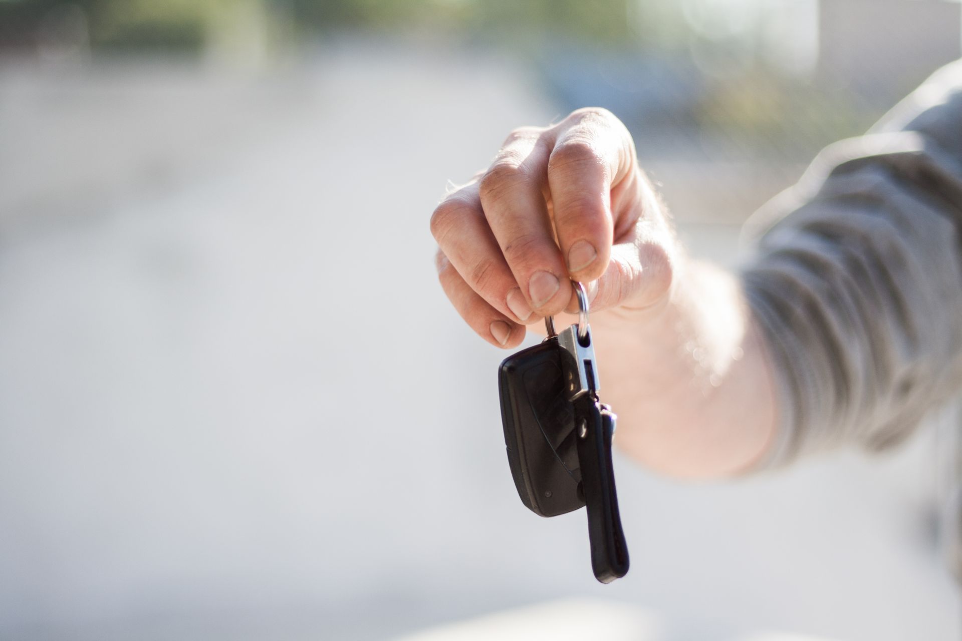 Auto locksmith returning replacement car keys to a relieved customer